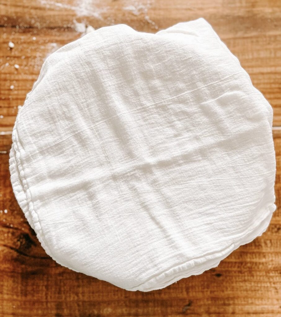 a bowl covered with a kitchen towel.