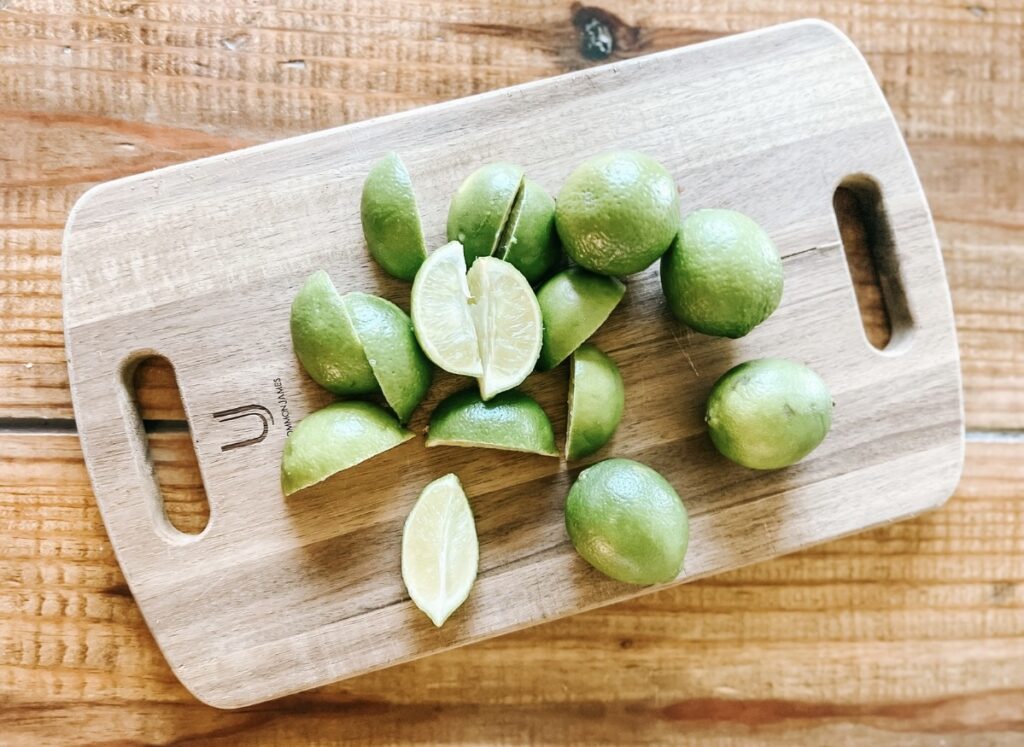 Limes on a wooden cutting board.
