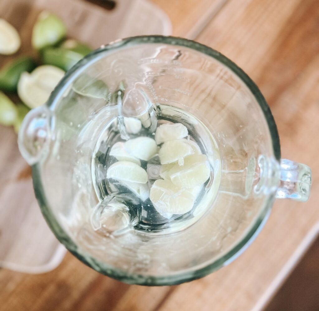 Peeled limes inside a blender.