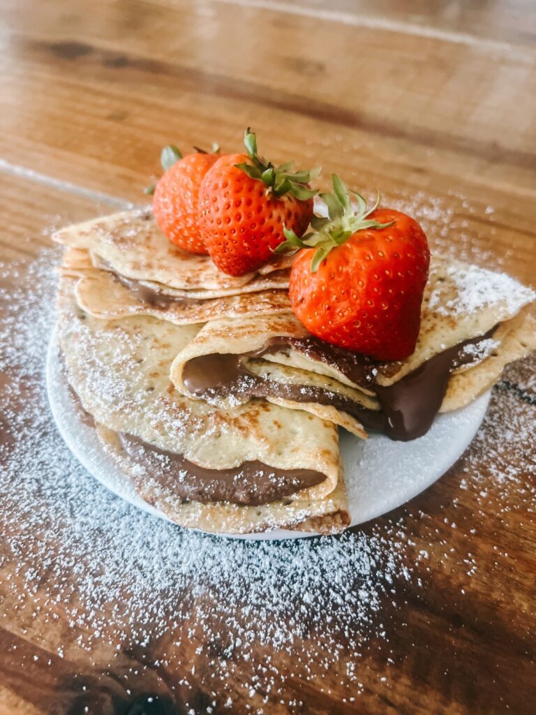 Sourdough discard crepes filled with chocolate and strawberries on top.